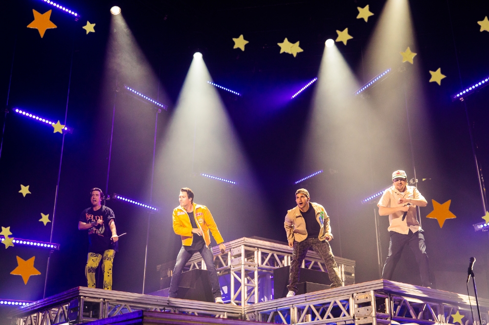 Foto da boy band Big Time Rush em apresentação da 'Forever Tour' em São Paulo com detalhe de estrelas aplicadas nas bordas.