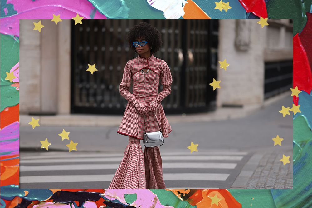 Look do street style da semana de moda de Paris com bolsa prata metalizada. Montagem em fundo de tintas coloridas com estrelinhas douradas