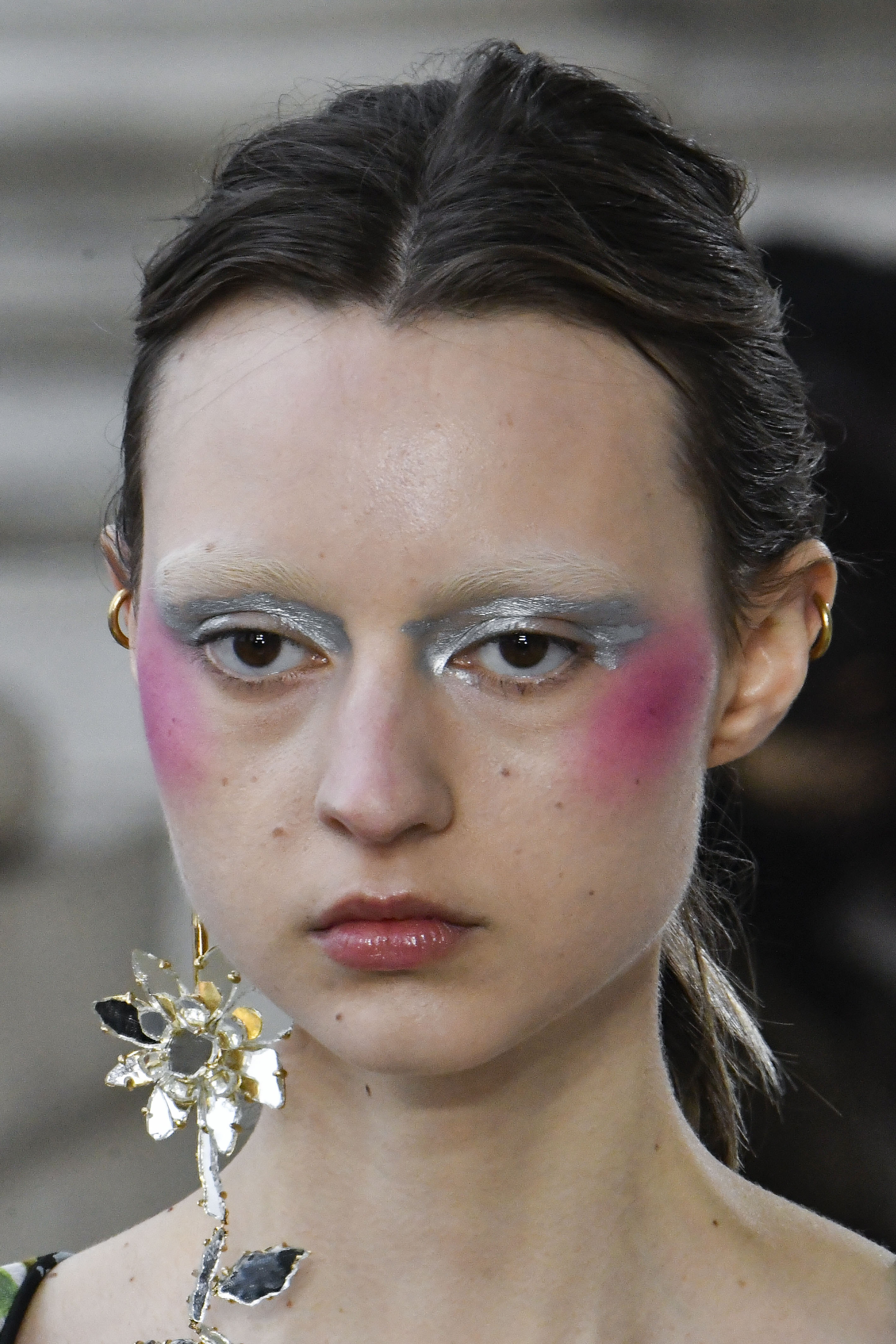Modelo usando sombra metalizada, sobrancelhas descoloridas e blush rosa marcado no Desfile de outono-inverno 2023-24 da Vivienne Westwood na semana de moda de Paris