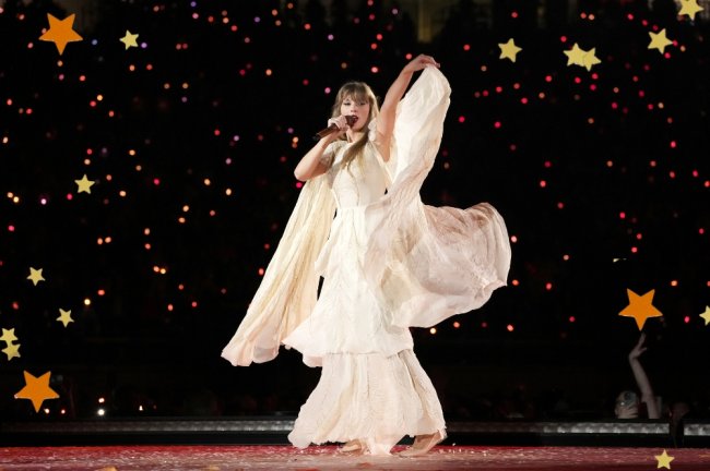 Foto da Taylor Swift no palco durante a 'The Eras Tour' com um vestido.
