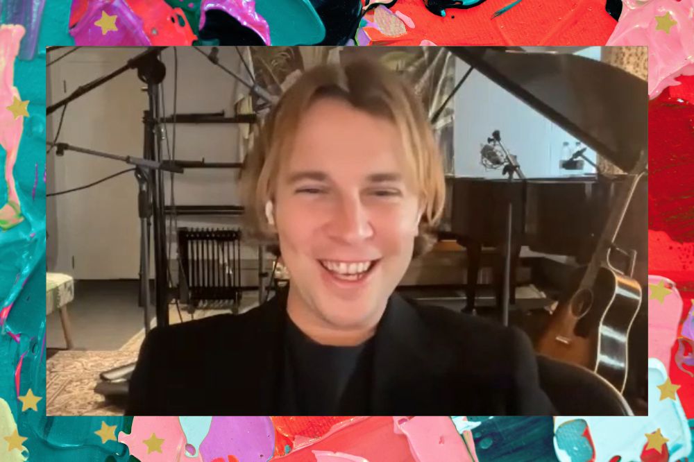 Tom Odell sorrindo em entrevista para CH; a margem é uma textura nas cores azul, verde, roxo, vermelho, lilás e preto; estrelas amarelas decoram a imagem