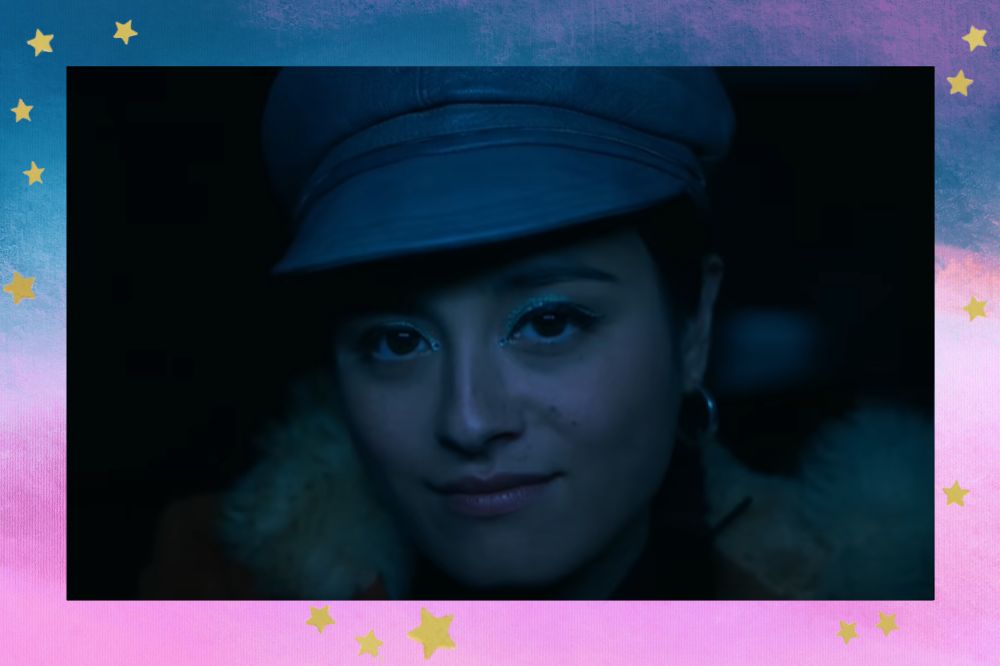 Sam, protagonista de Cidade em Chamas, sorrindo levemente em uma cena da série; a margem é uma textura nas cores lilás, azul, roxo, rosa e branco com estrelas amarelas como decoração