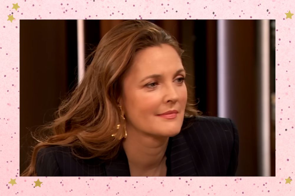 Drew Barrymore sorrindo levemente em entrevista; a margem é uma textura rosa com bolinhas; estrelas amarelas decoram a imagem