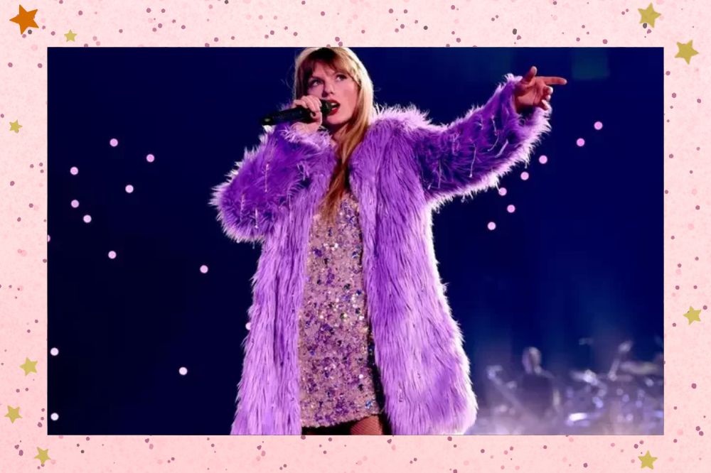 Taylor Swift segurando o microfone em palco cheio de luzes em um fundo escuro. Ela veste um vestindo cheio de pedras e um casaco lilás peludo. Fundo rosa claro com estrelas douradas.
