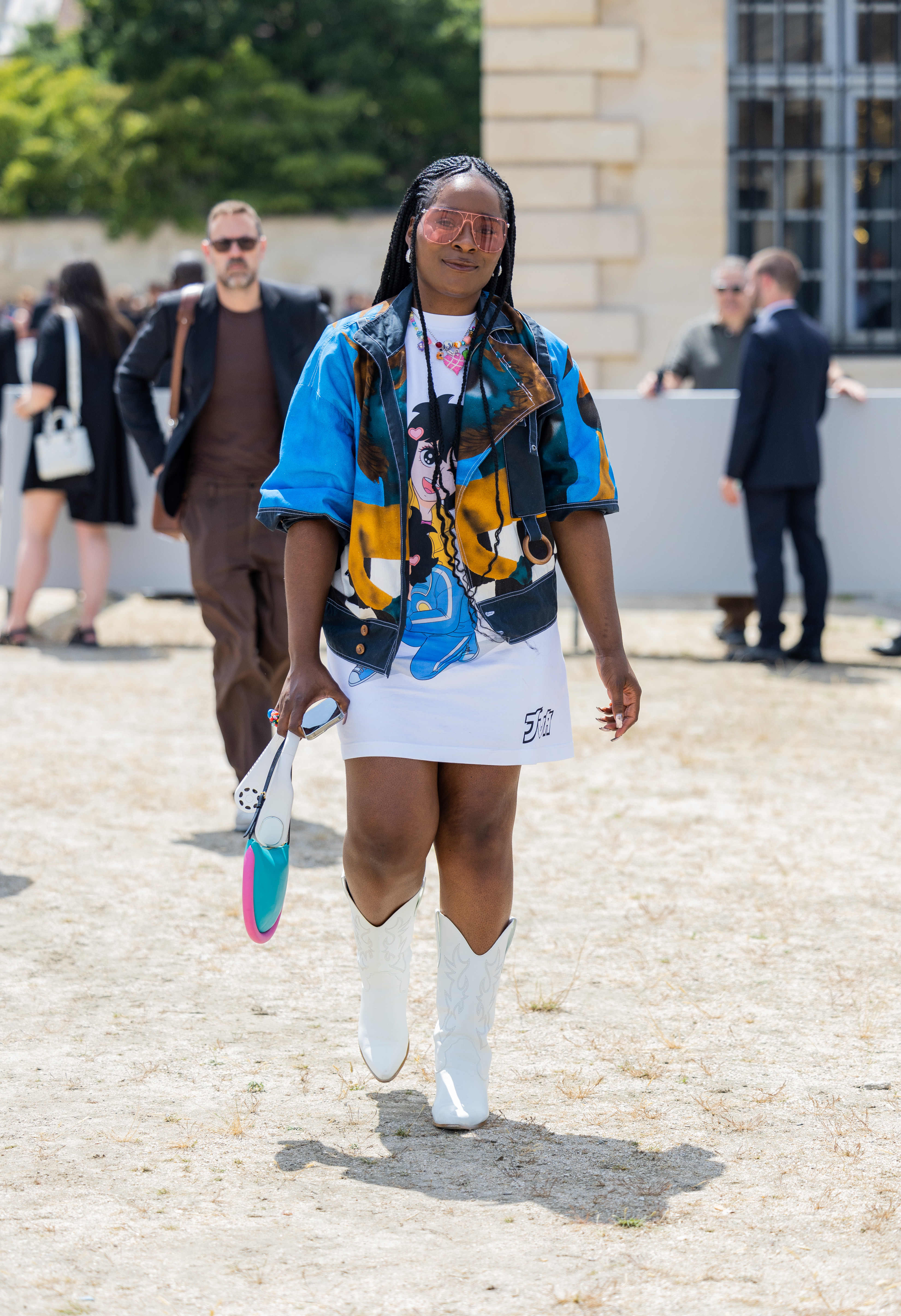 Street Style – Paris Fashion Week – Menswear Spring/Summer 2024 : Day Four Look no street style da semana de moda masculina de primavera-verão 2024 em Paris. Mulher usando vestido branco estampado com camisa azul por cima e bota western branca