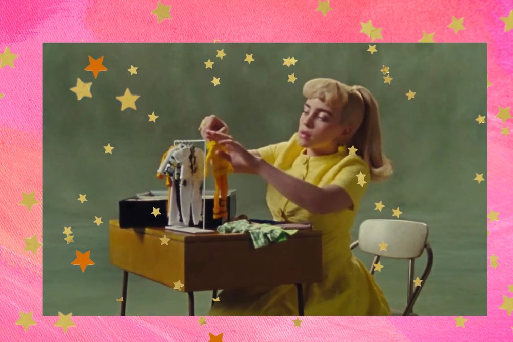 Frame de Billie Eilish no clipe de What Was I Made For?. Montagem com várias estrelas douradas e fundo rosa.