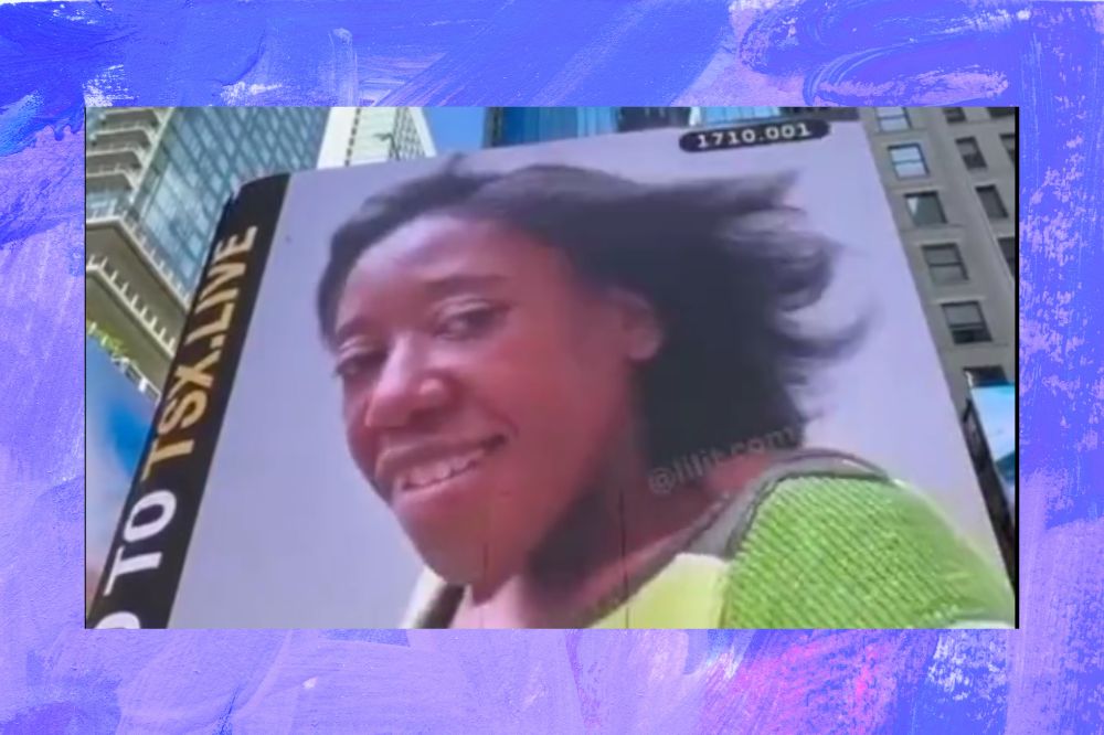 Na foto aparece um outdook com a imagem de uma mulher negra de cabelo curto