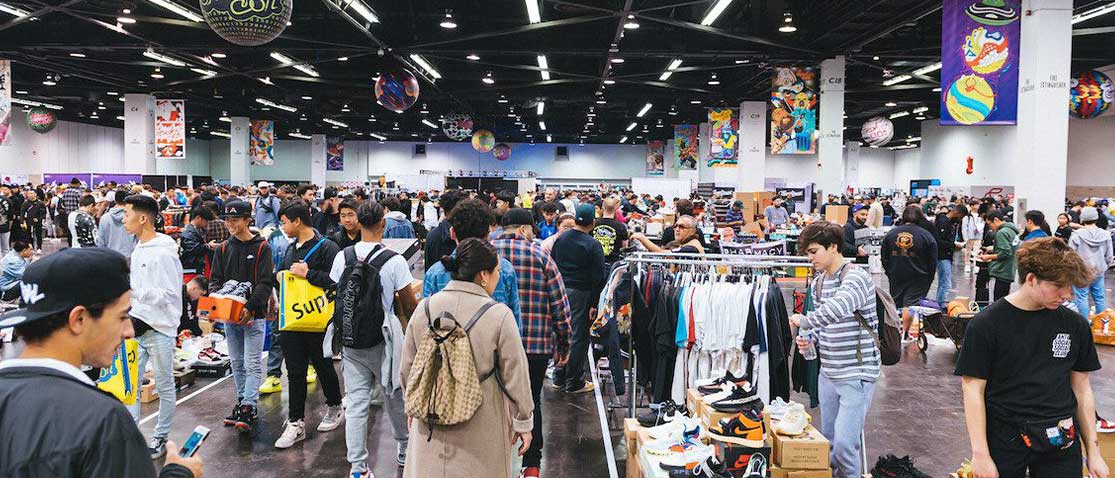 Muitas pessoas em uma feira de compra e venda de sneakers, tênis.