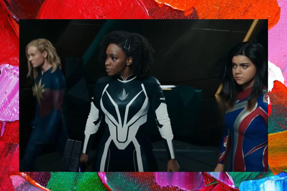 Três heroínas reunidas em trailer de As Marvels; elas estão alinhadas com expressões sérias enquanto olham para frente; a margem é uma textura nas cores vermelho, laranja, rosa, azul, verde, roxo e branco