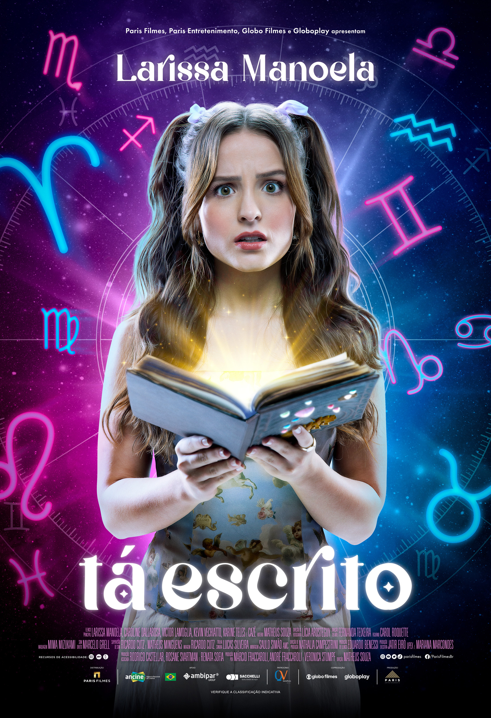 Larissa Manoela em pôster de Tá Escrito; ela está com expressão de surpresa e confusão enquanto segura um livro; símbolos de signos do zodíaco estão ao fundo da imagem nas cores rosa, azul e roxo; o nome do filme aparece em branco na parte central inferior da imagem