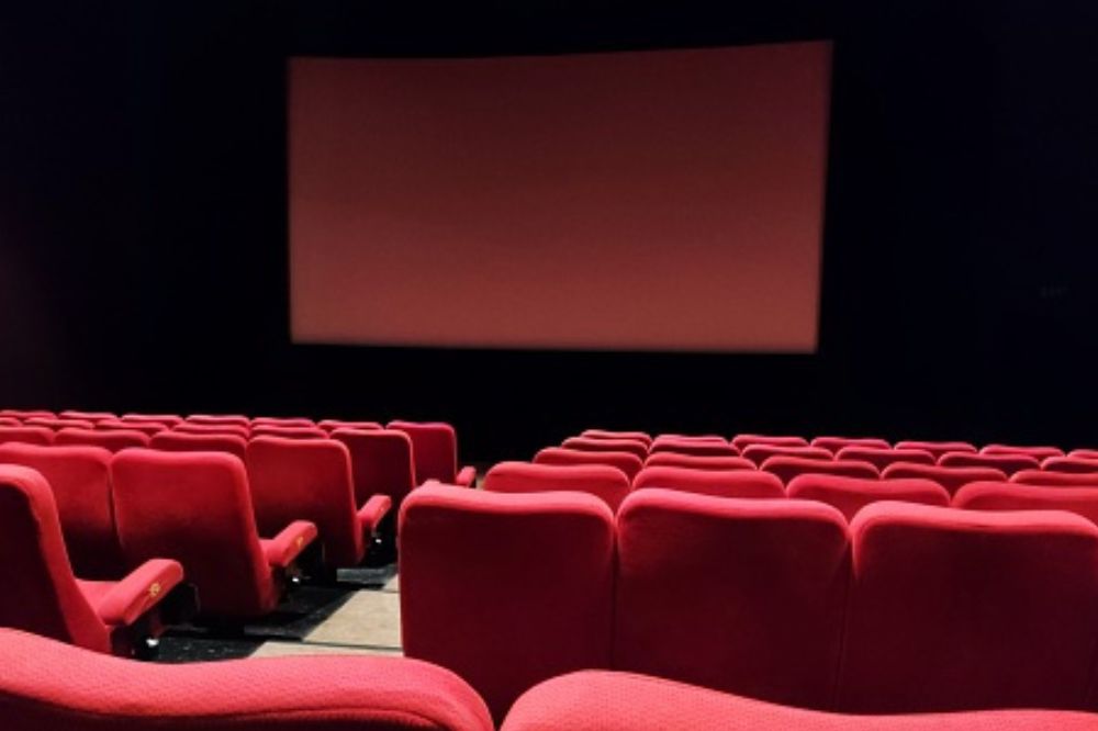 Imagem de uma sala de cinema com cadeiras vermelhas