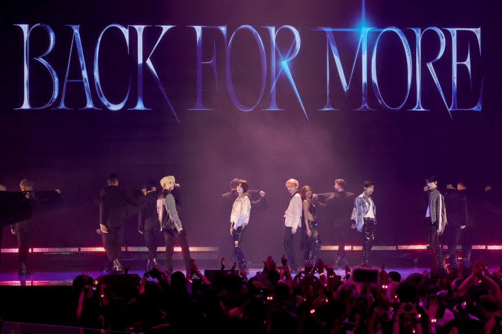 Anitta e TXT no VMA 2023; eles estão no palco rodeados por dançarinos apresentando a música 'Back For More', que tem seu nome exibido no telão de fundo, atrás dos artistas