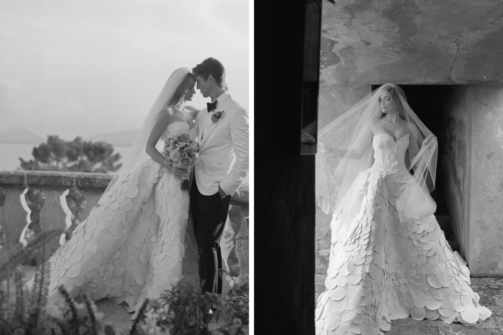 Noivo e noiva pousam para fotos; Ela usa vestido longo, com flores bordadas; E ele, terno branco