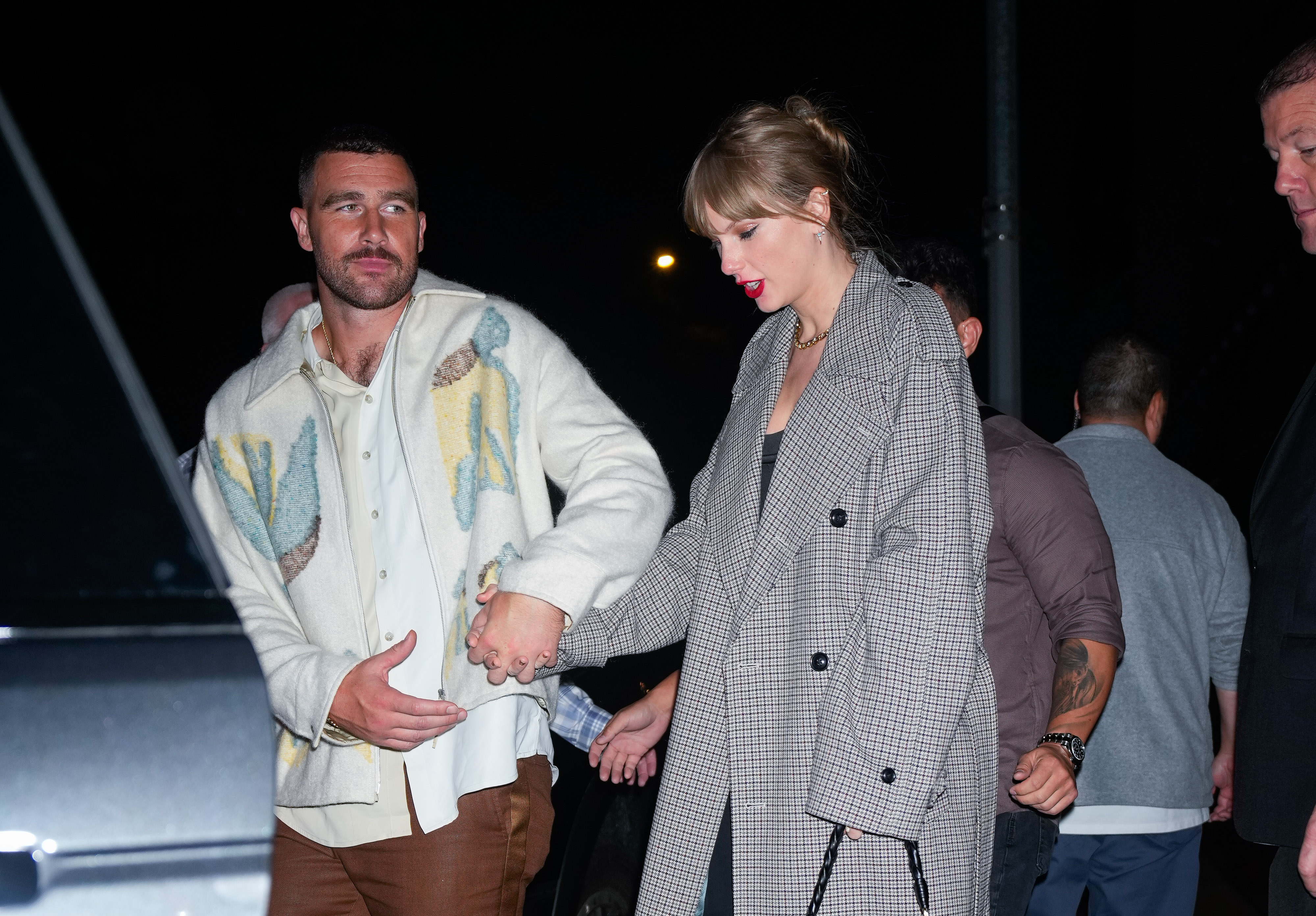 Travis Kelce e Taylor Swift andando de mãos dadas durante a noite em Nova York