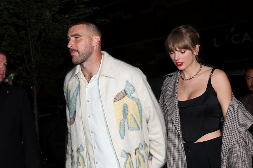 Travis Kelce e Taylor Swift andando de mãos dadas durante a noite em Nova York