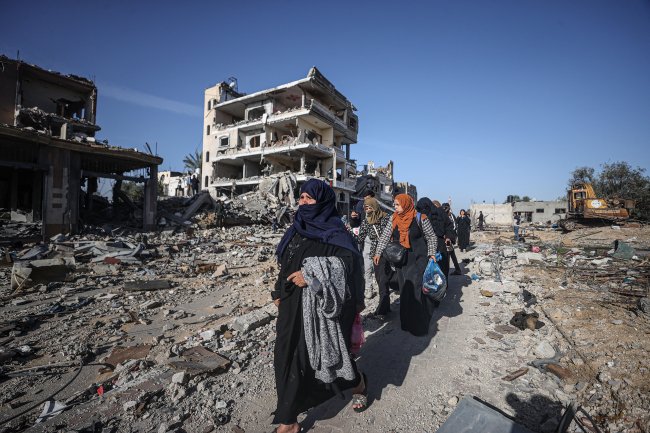 Faixa de Gaza Mulheres andam em meio a destruição