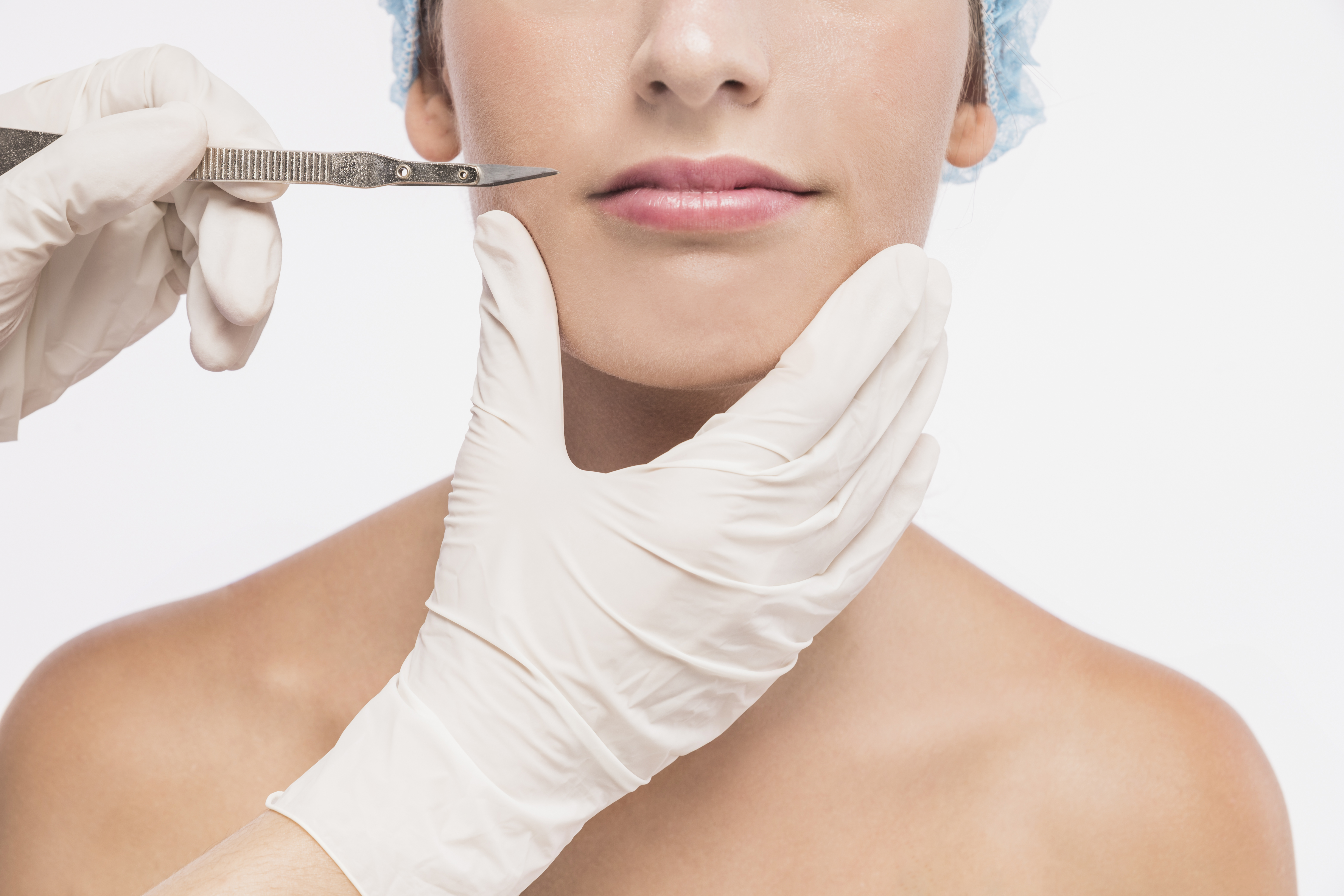 doutor-segurando-bisturi-perto-mulher-labios Dermaplaning: procedimento estético que usa bisturi para remover células mortas e pelos faciais