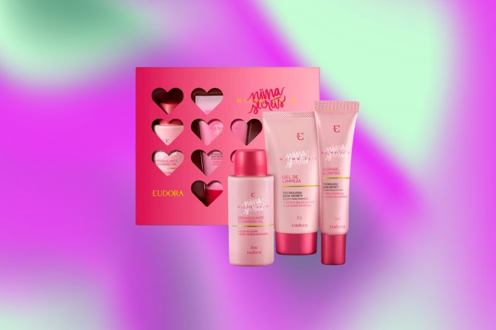 Uma caixa rosa com corações e na frente dela, três produtos de limpeza facial em embalagens rosa