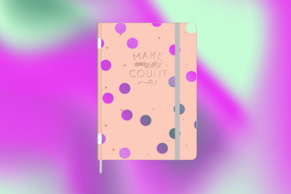 Em um fundo rosa, roxo e verde, aparece a capa de um caderno cor de pêssego