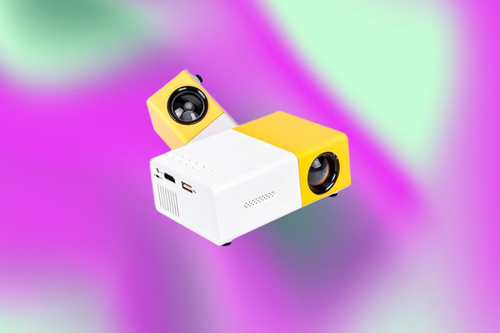 Em um fundo roxo e verde, o projetor é metade branco e metade amarelo. Na parte amarela, na frente, fica a lente.
