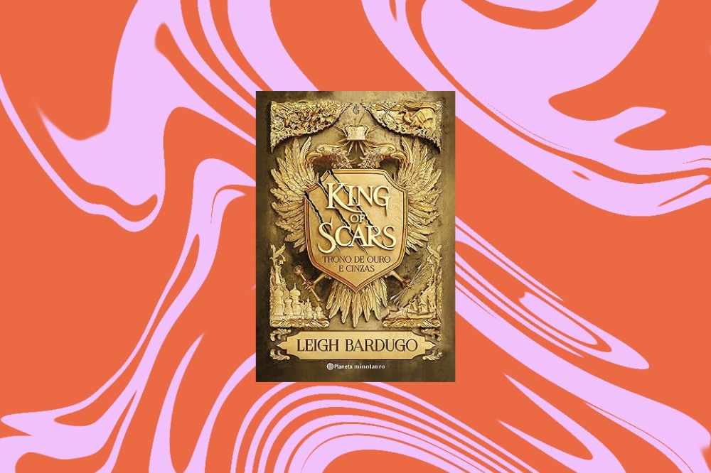 Imagem do livro "King of Scars", com uma capa imitando madeira, em um fundo laranja e rosa