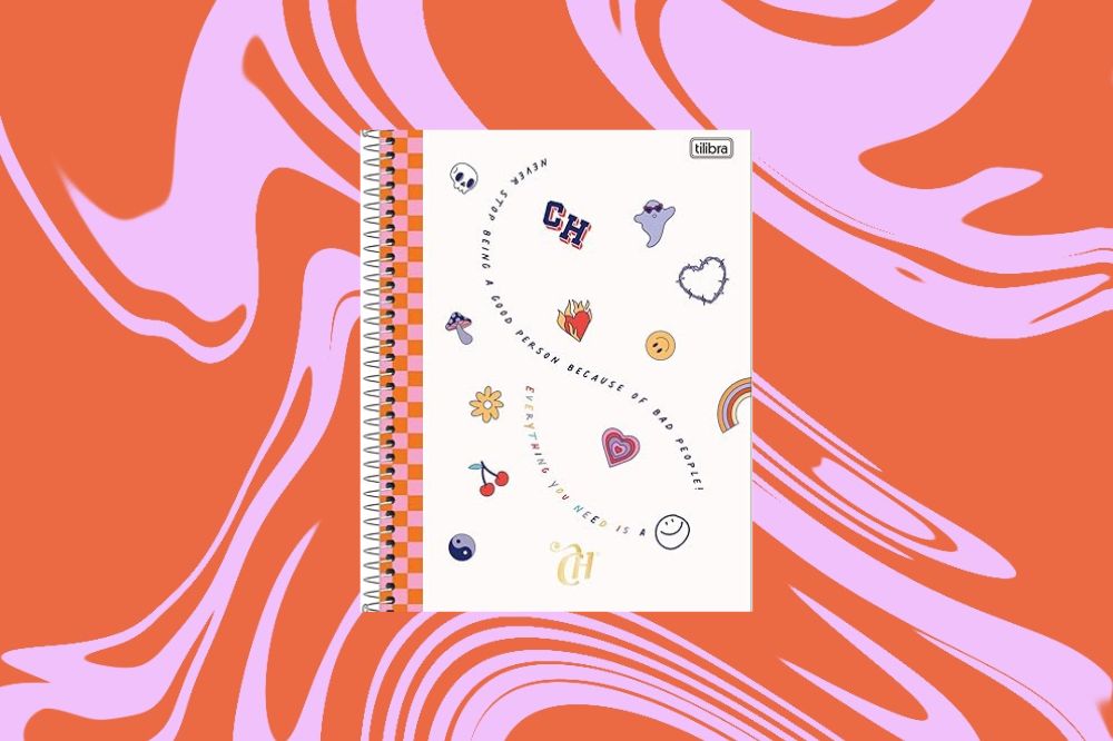 Caderno com fundo bege co elementos como coração, fantasma, cereja e flor coloridos, em um fundo laranja e rosa