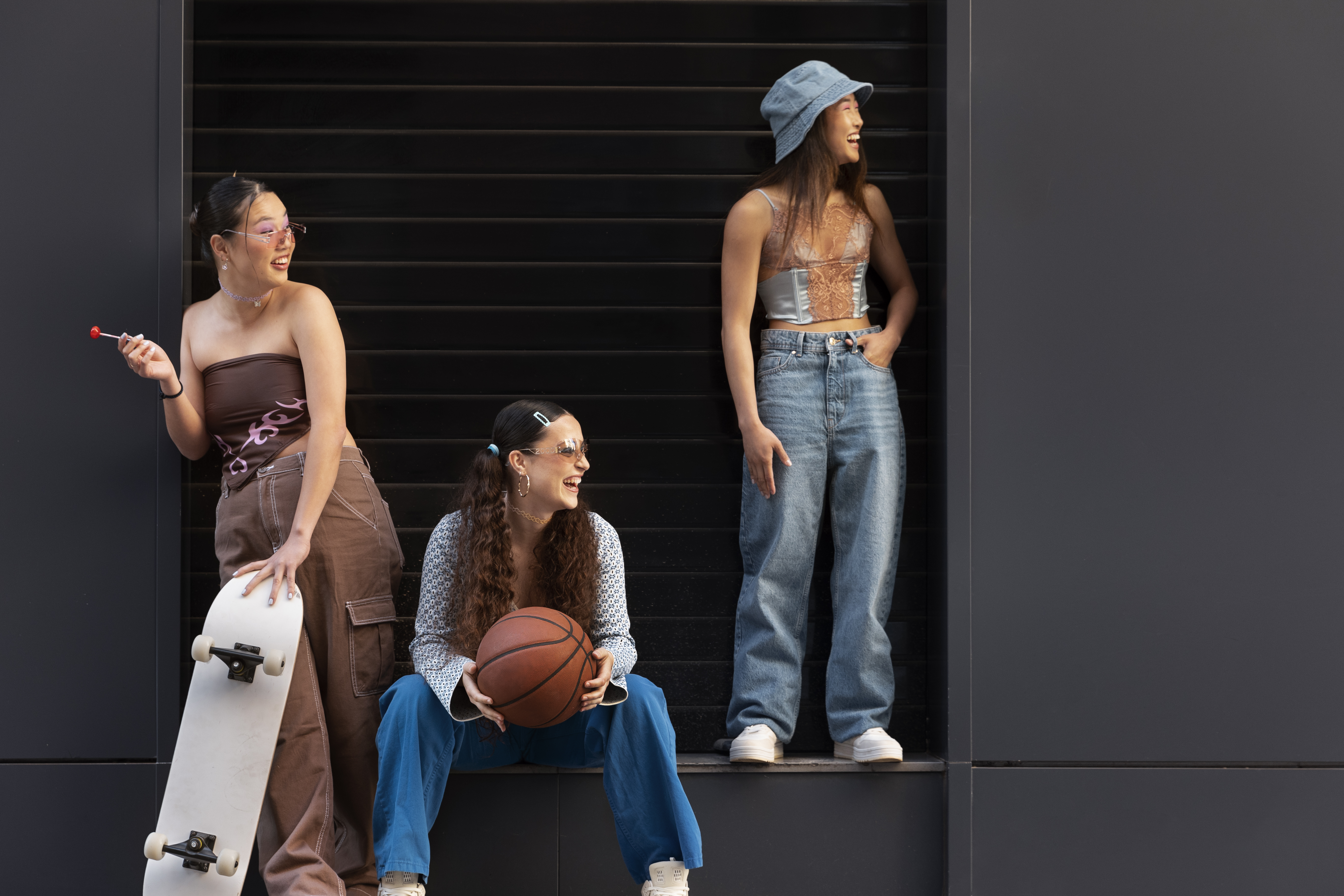 Três mulheres jovens usando looks com tendências dos anos 2000