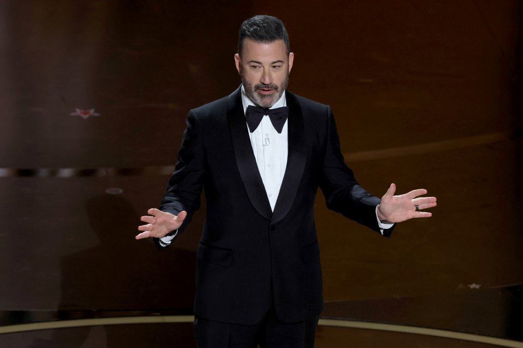 Jimmy Kimmel no palco do Oscar fazendo a apresentação da cerimônia com os braços abertos enquanto fala