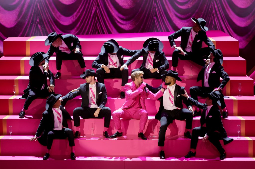 Ryan Gosling na performance de I'm Just Ken do Oscar; ele está sentado em uma escadaria rosa com outros dançarinos