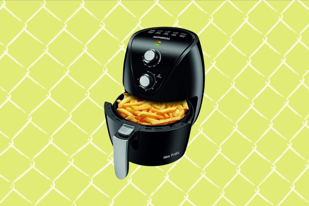 Receitas muito práticas para fazer na air fryer Imagem de uma air fryer preta aberta com batata frita dentro, em um fundo amarelo.