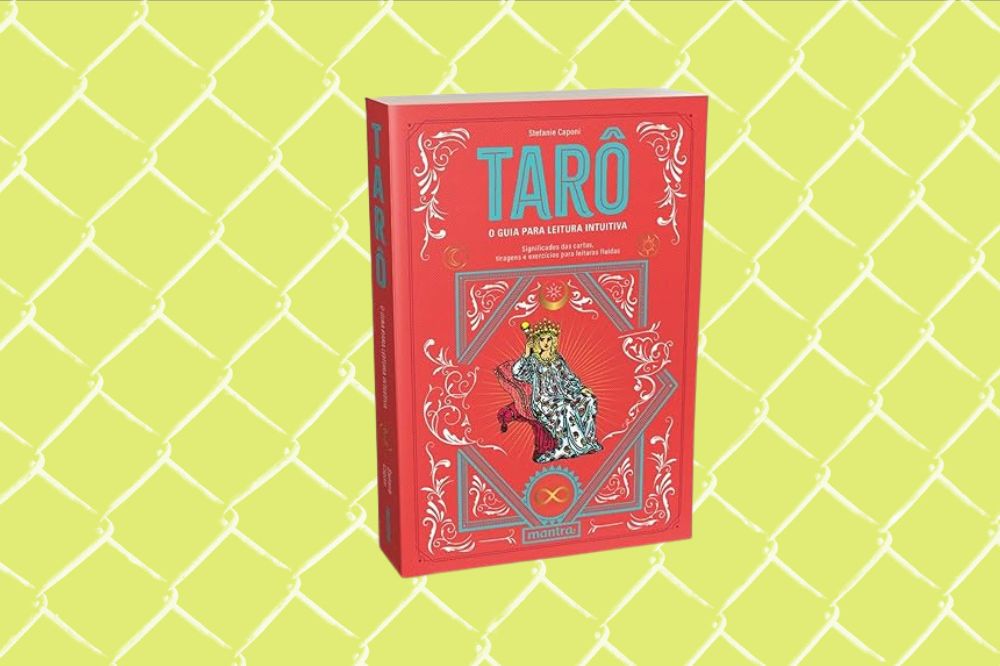 Imagem de um livro de tarot vermelho em um fundo amarelo.
