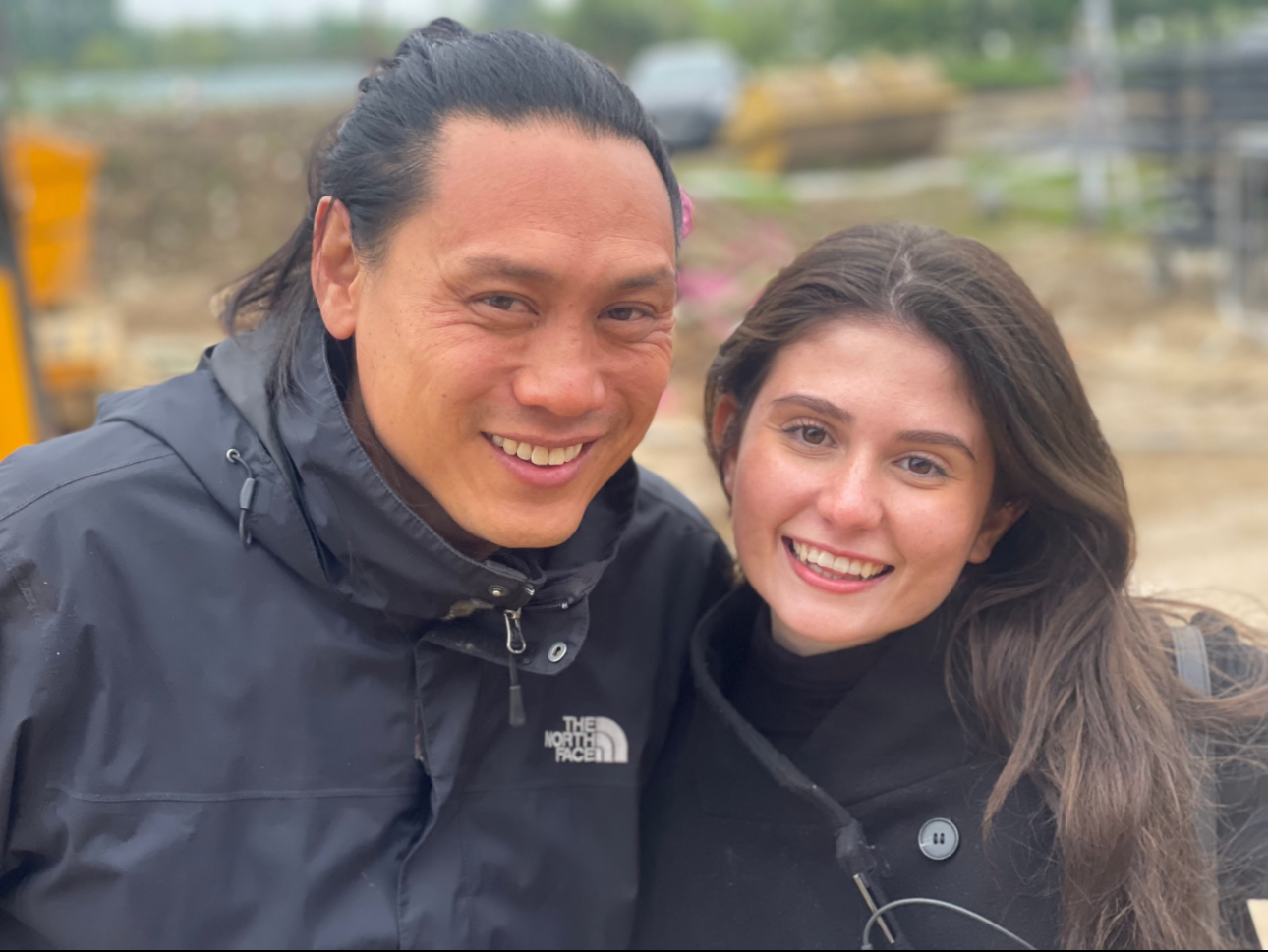 Isabelle Bernardo e diretor Jon M. Chu no set de Wicked; eles estão posando para foto e sorrindo
