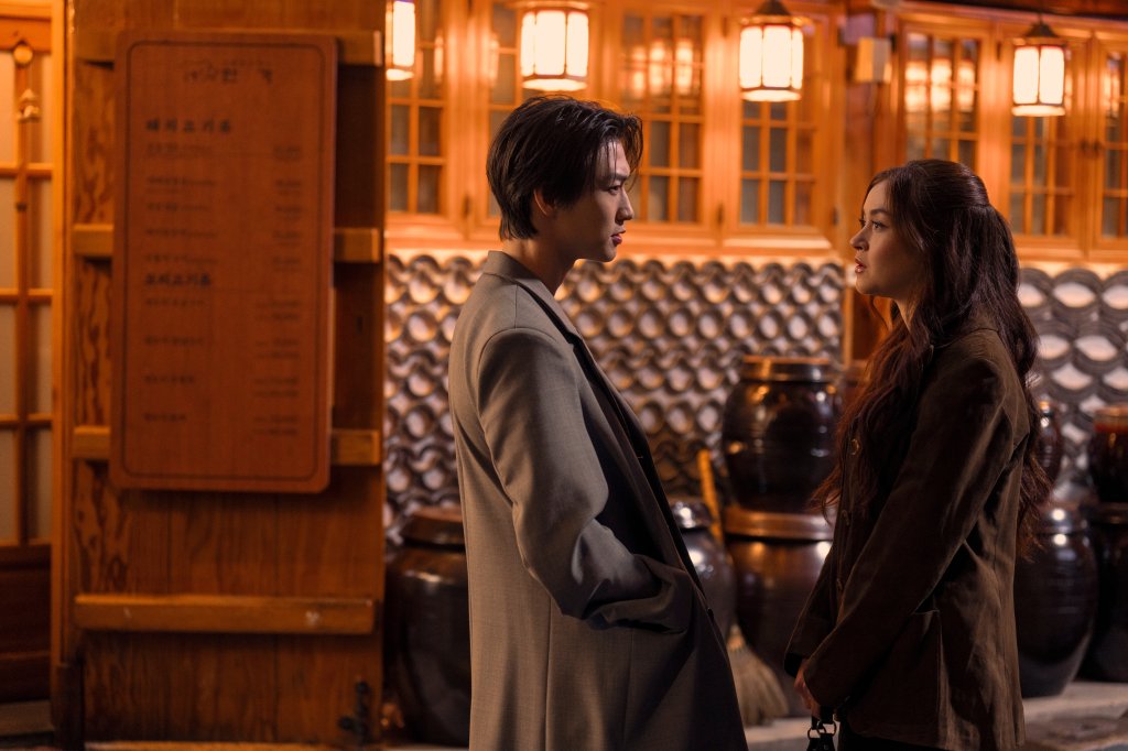 Sang Heon Lee como Min Ho Moon e Anna Cathcart como Kitty Song Covey em Com Carinho, Kitty; eles estão se olhando enquanto conversam na rua durante a noite