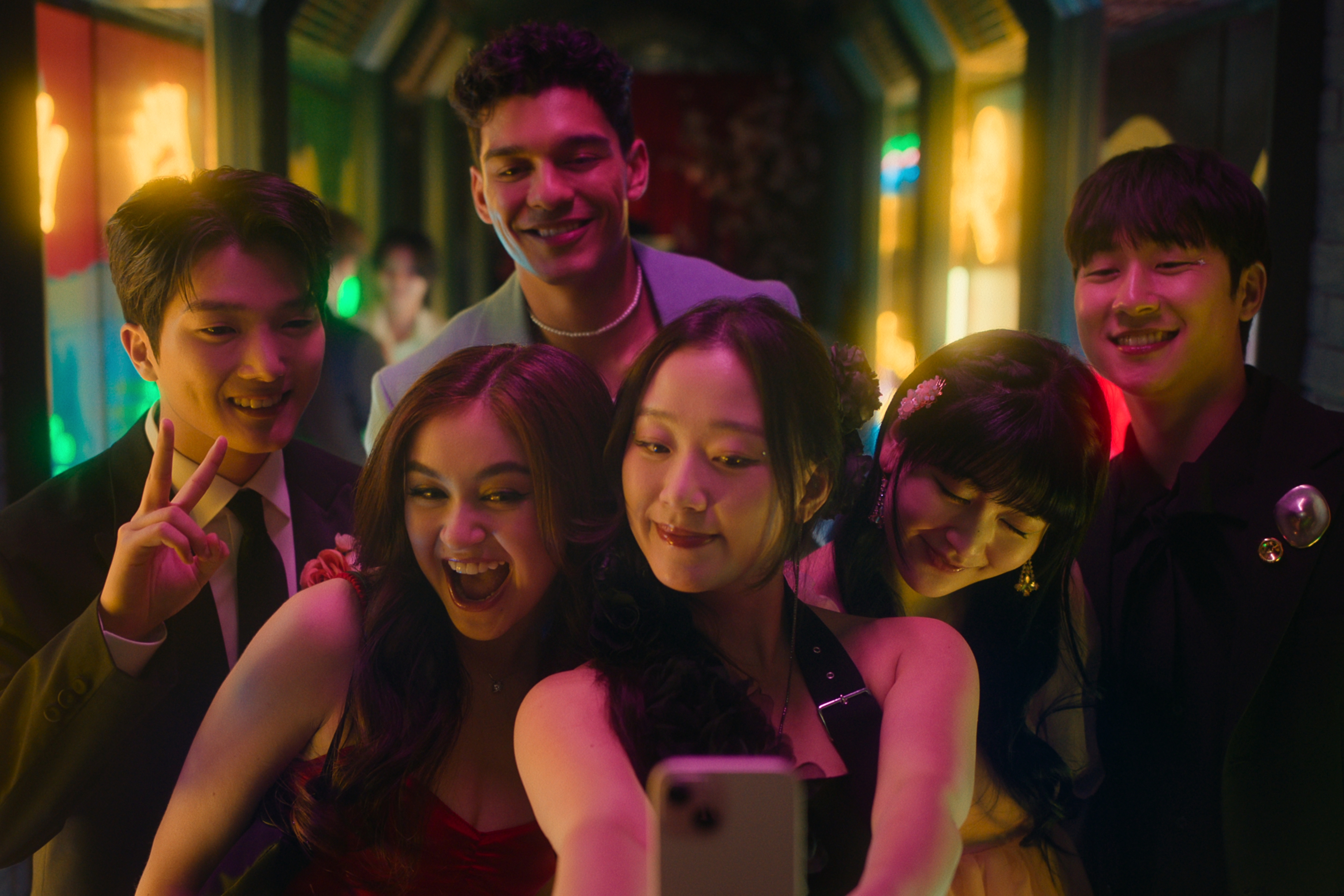 XO_Kitty_n_S2_E7_00_18_42_05R Minyeong Choi como Dae Heon Kim, Anna Cathcart como Kitty Song Covey, Anthony Keyvan como Quincy 'Q' Shabazian, Gia Kim como Yuri Han, Han Bi Ryu como Eunice Kang, Joshua Hyunho Lee como Jin; eles estão sorrindo enquanto tiram uma selfie juntos