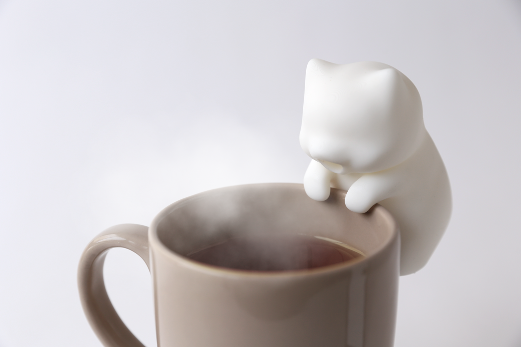 gato robô Imagem do gato-robô que assopra comidas e bebidas, apoiado em uma caneca marrom.