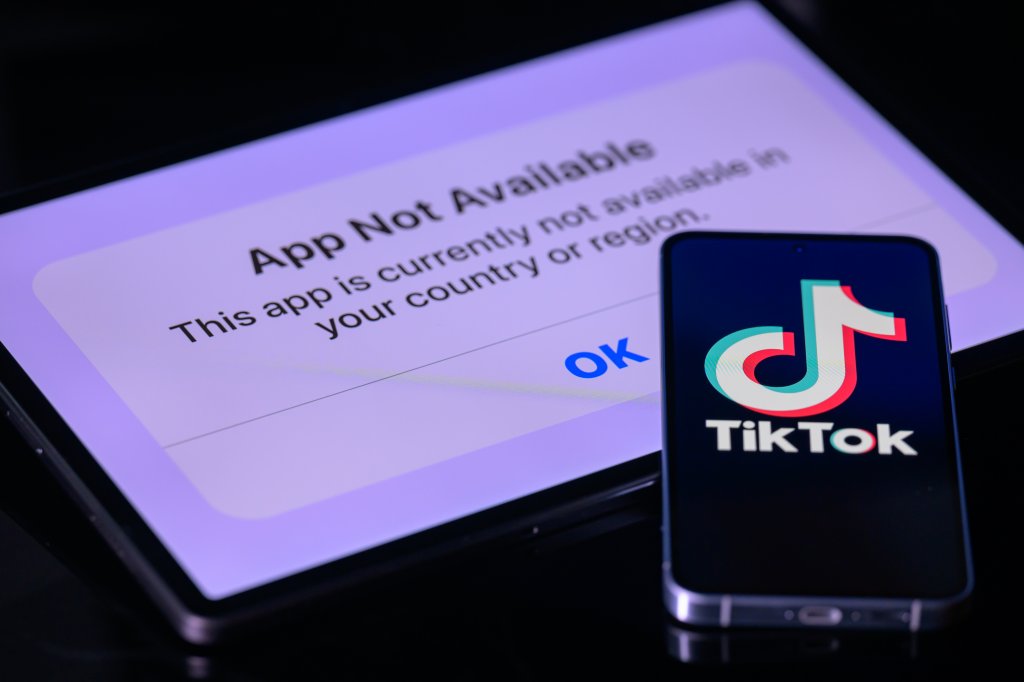 O logotipo do TikTok aparece na tela de um celular, enquanto o aplicativo não está disponível na tela de um tablet nesta fotoilustração feita pelo Getty Images em Bruxelas, Bélgica, em 19 de janeiro de 2025.