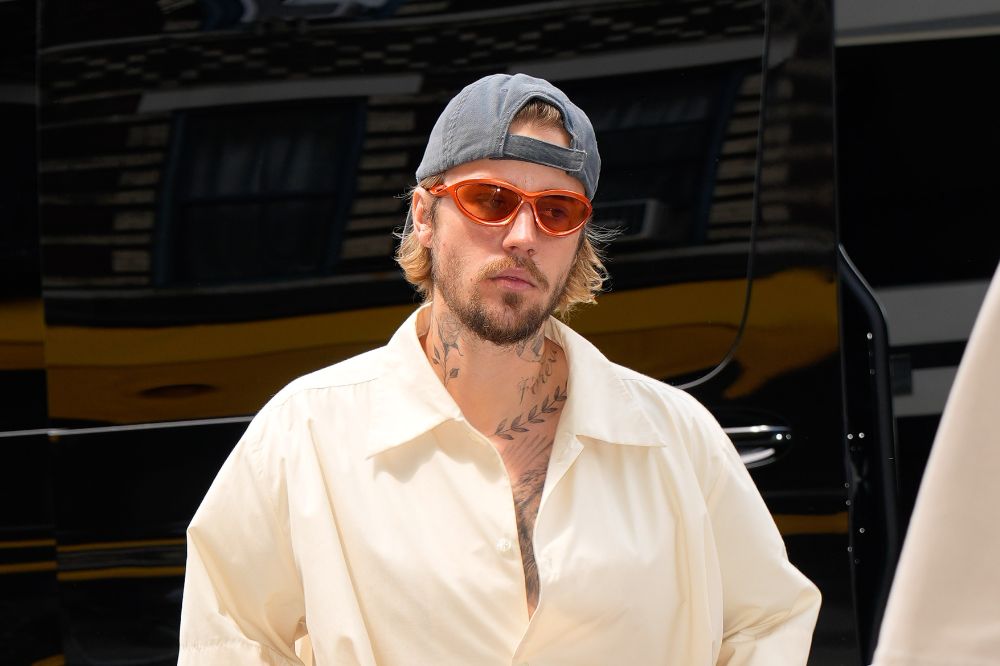 Justin Bieber com boné azul e óculos laranja