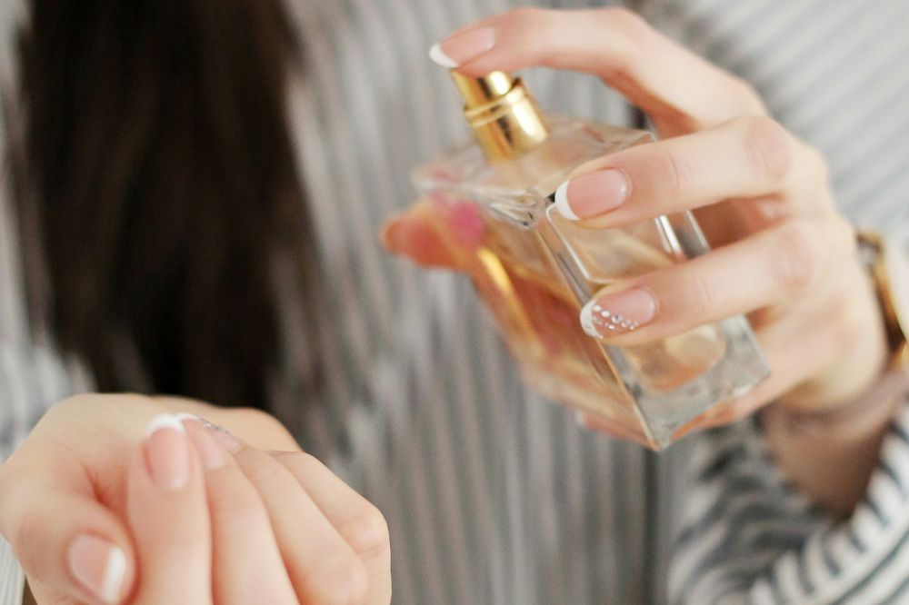 Mulher aplicando perfume no pulso