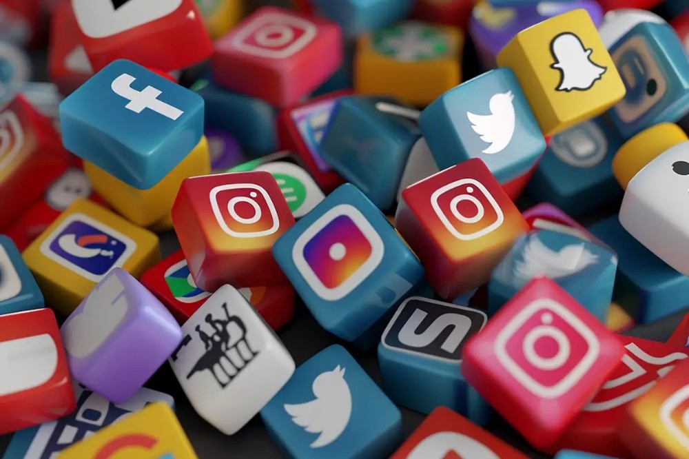 Muitos cubos coloridos com logotipos de redes sociais e aplicativos, como Facebook, Instagram, Twitter e Snapchat, espalhados aleatoriamente