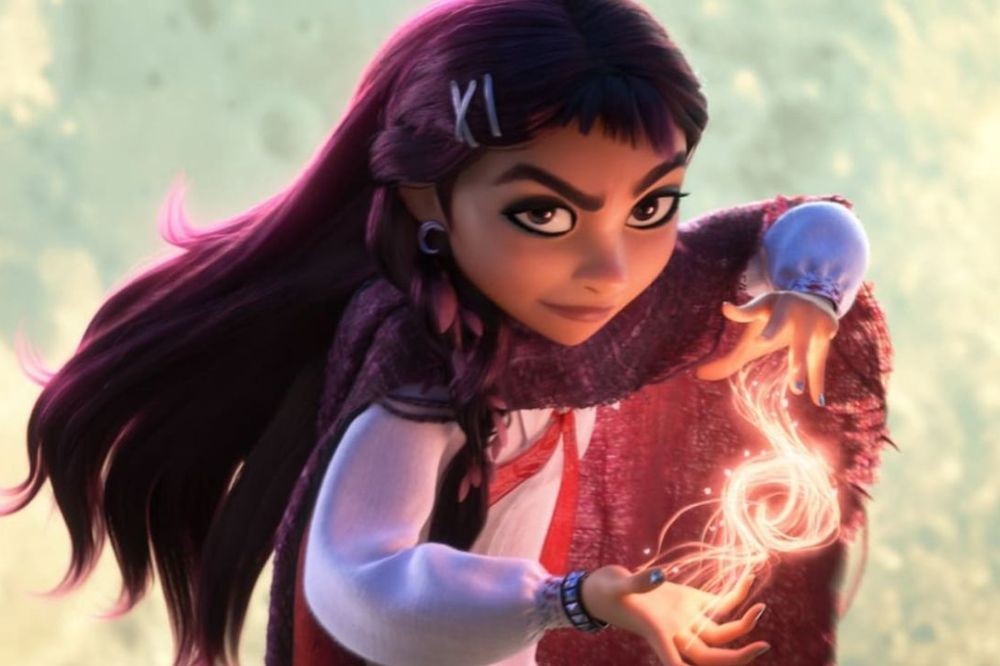 Personagem Asha de Wish: O Poder dos Desejos, com cabelo longo roxo e presilhas brancas, vestindo capa vermelha e blusa branca. Ela tem expressão séria e está com as mãos abertas, criando um feitiço de luz laranja brilhante