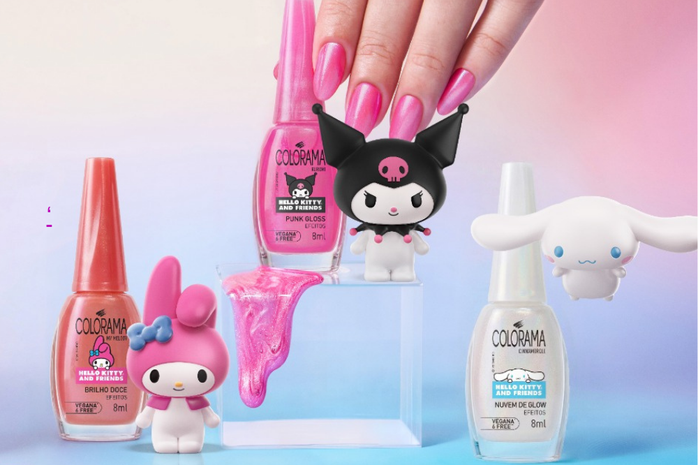 Três esmaltes Colorama da coleção Hello Kitty and Friends, com miniaturas dos personagens My Melody, Kuromi e Cinnamoroll. Uma mão com unhas pintadas de rosa segura um dos frascos, enquanto esmalte rosa brilhante escorre sobre um pedestal transparente. O fundo é um degradê de rosa e azul