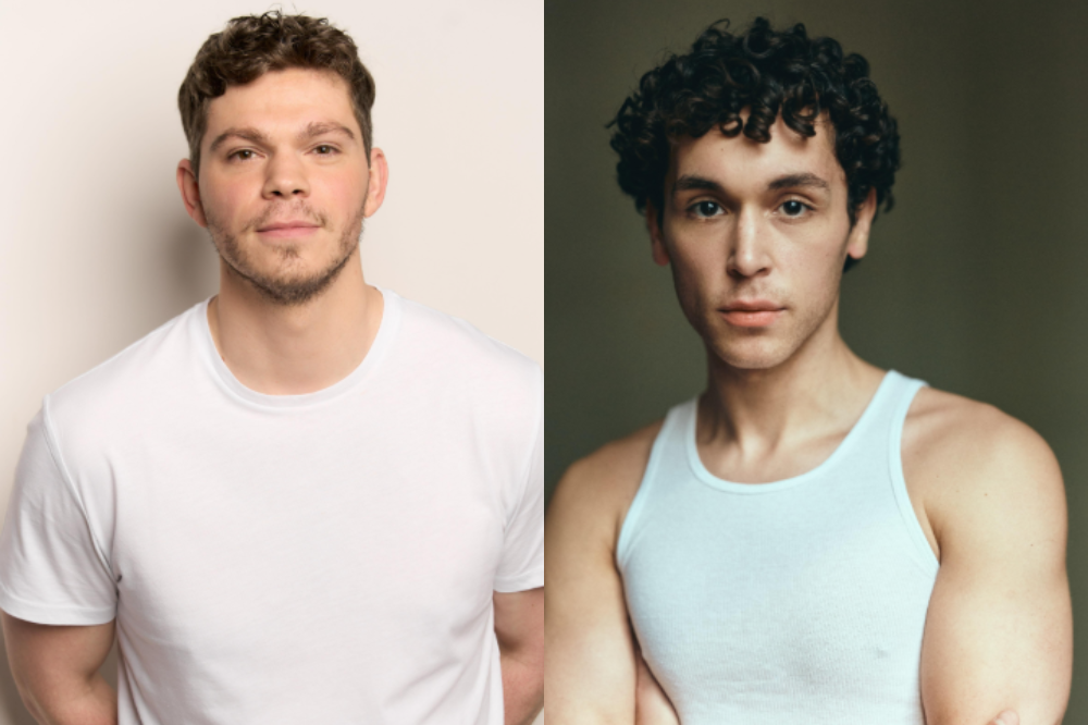 Dois homens jovens, um à esquerda com cabelo castanho curto e barba rala, vestindo camiseta branca, e outro à direita com cabelo cacheado escuro, vestindo regata branca, ambos olhando para frente com expressão séria