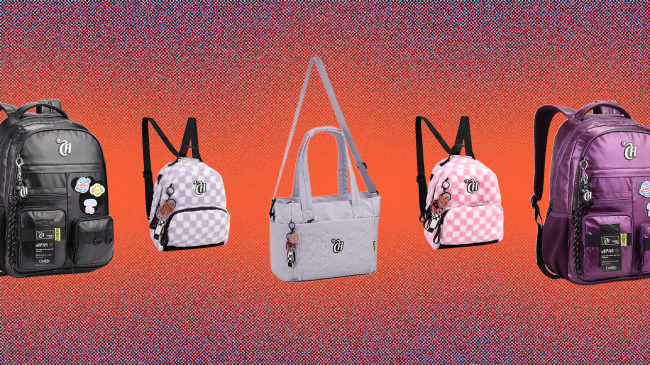 Cinco bolsas e mochilas juvenis em fundo laranja e roxo. Da esquerda para a direita: mochila preta com adesivos coloridos, mochila xadrez lilás e branca, bolsa cinza com alça de ombro, mochila xadrez rosa e branca, e mochila roxa com adesivos