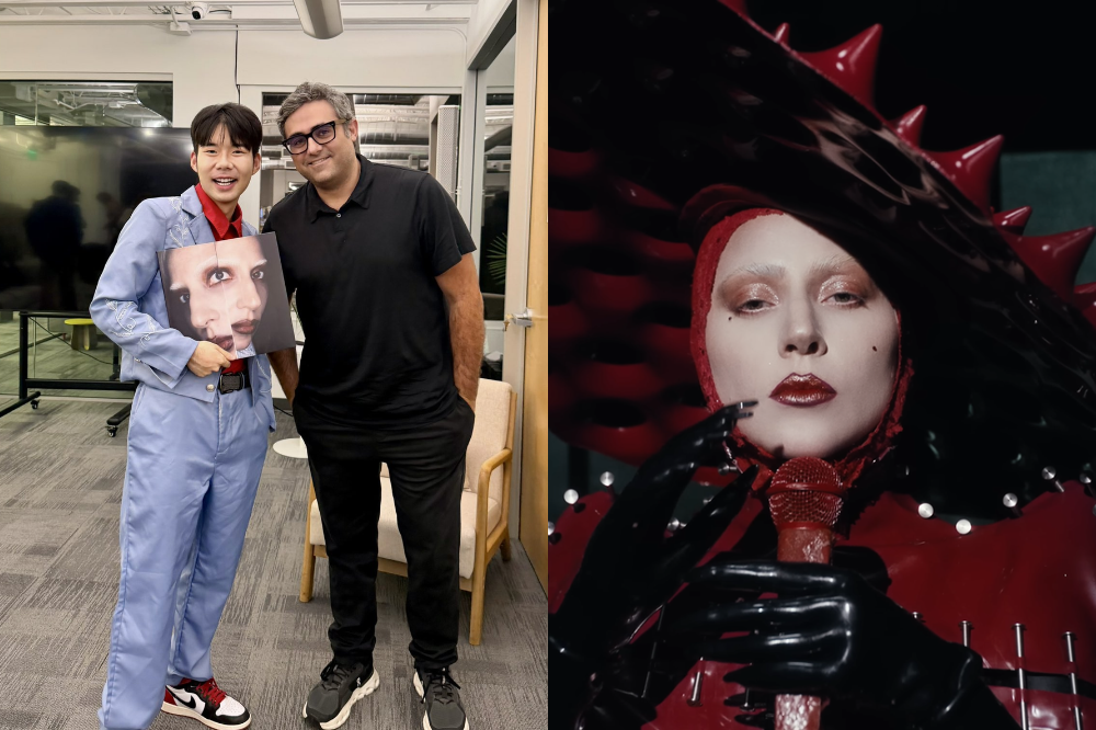 À esquerda, um homem asiático sorridente de terno azul e camisa vermelha segura um disco com o rosto de Marilyn Manson, ao lado de um homem de óculos e camisa polo preta. À direita, Lady Gaga com maquiagem pálida, batom vermelho, capuz e luvas pretas de látex, e um vestido vermelho com detalhes pontiagudos, segurando um microfone vermelho